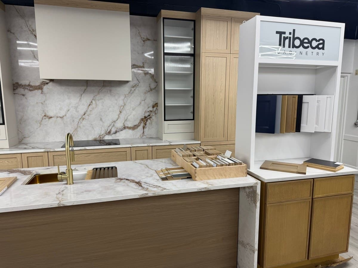 Kitchen showroom with a marble-look waterfall island, cabinet door samples and finish swatches in Tampa FL