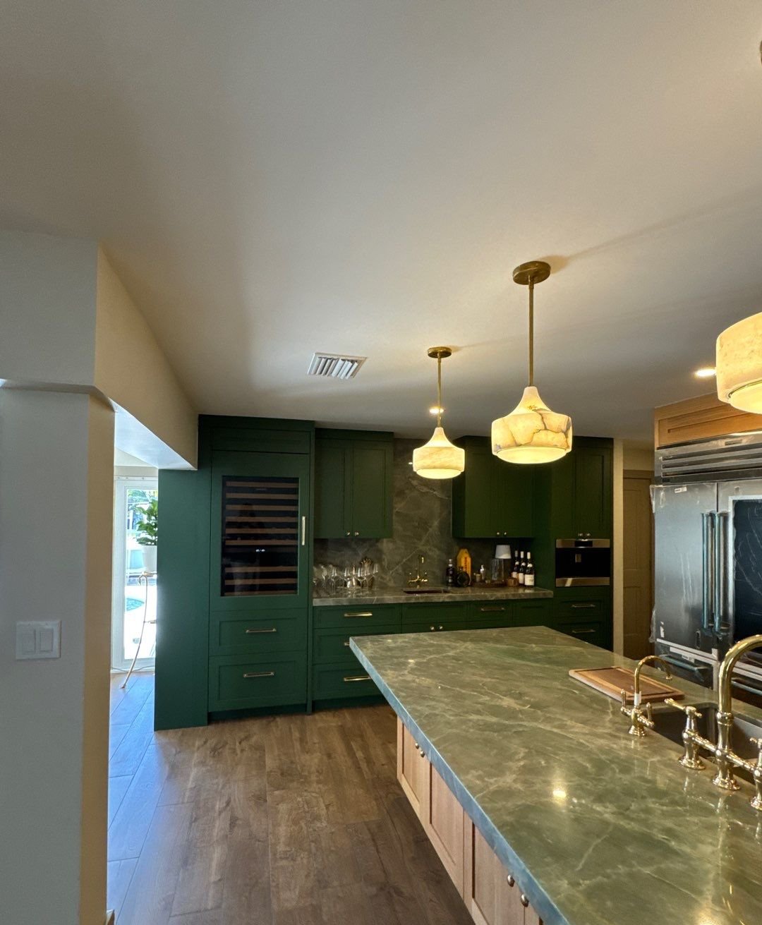 Deep green custom bar cabinetry with wine refrigerator in Saint Petersburg kitchen remodel